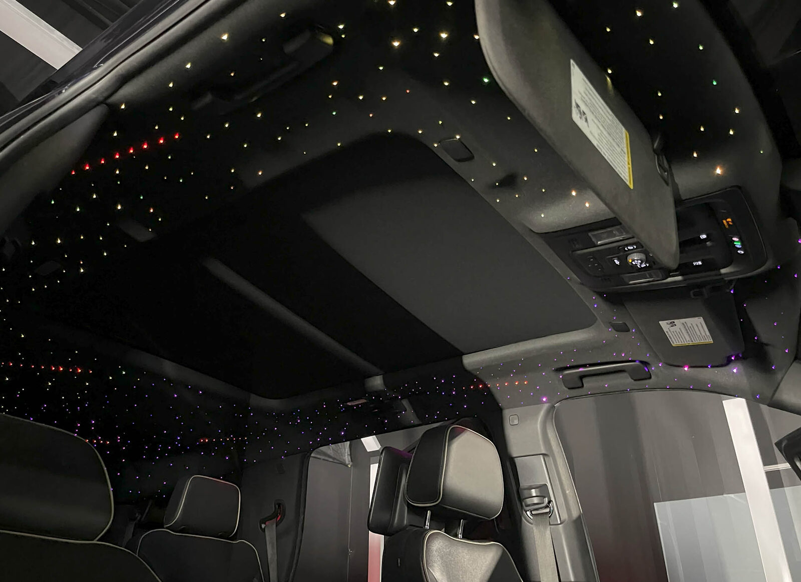 Starlight headliner glowing across an SUV cabin ceiling