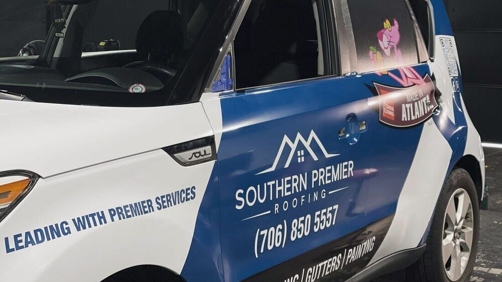Roofing company graphics on a work car